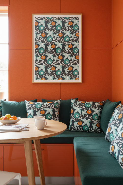 Modern sofa with patterned Holland Street Flight linen fabric cushions against an orange wall with a framed artwork. Contemporary and creative living