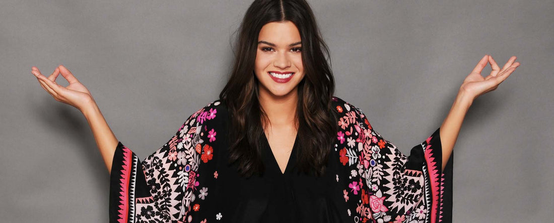 Lady in black and pink kaftan doing a buddah pose