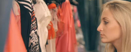 Woman Shopping a rail of silk kaftans in orange and black and white
