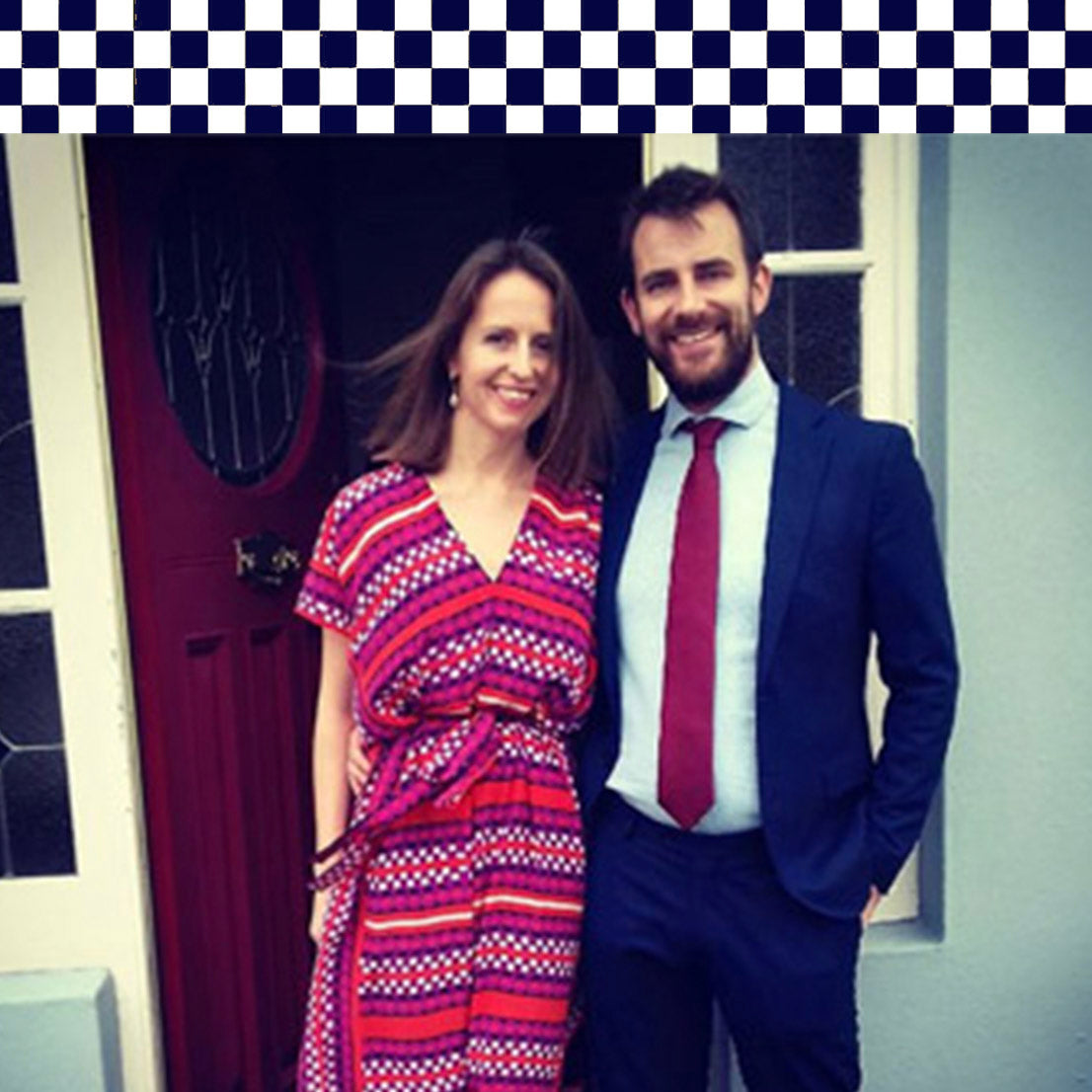 5 star customer review. Man and woman standing in front of a door with a checkered border at the top, wearing a luxury printed silk kaftan dress from Holland Street.